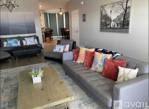 A living room with a grey couch and a wooden coffee table.