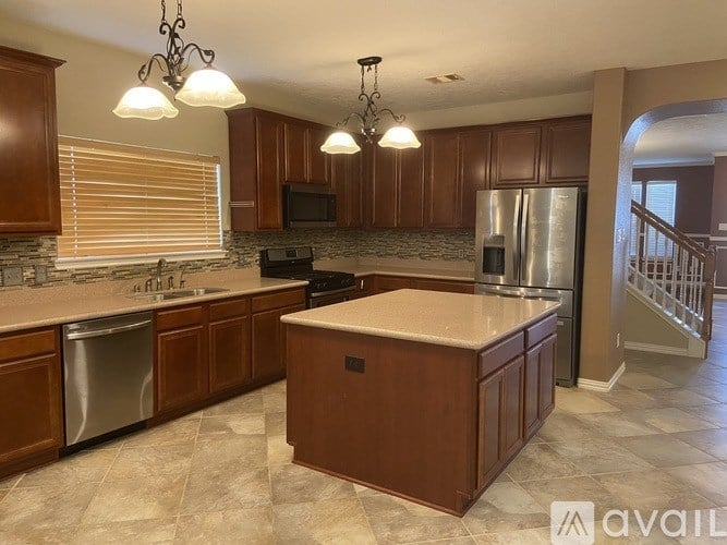 A kitchen with wooden cabinets and a marble countertop.