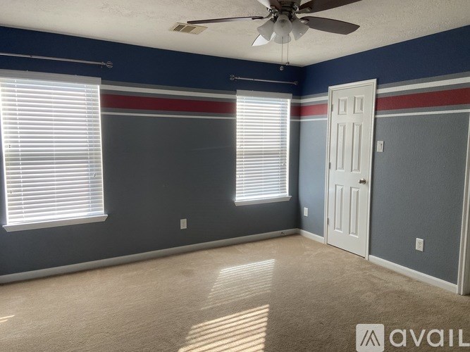 A room with a ceiling fan and a door.