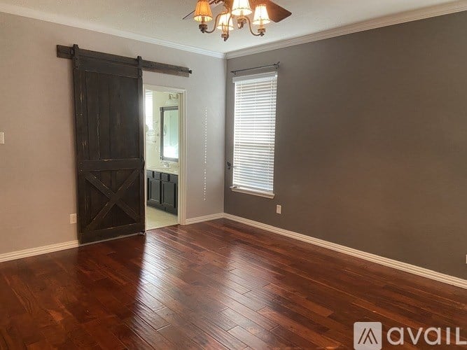 A room with a wooden floor and a chandelier.