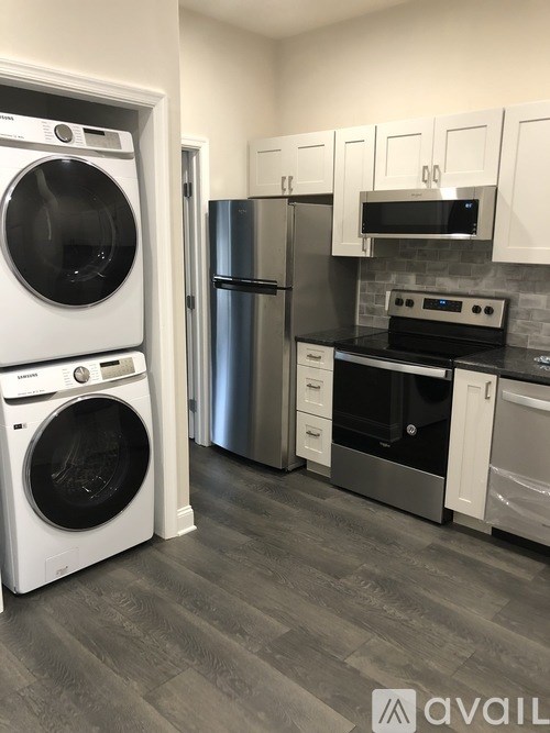 A modern kitchen with a washer and dryer in the laundry room.