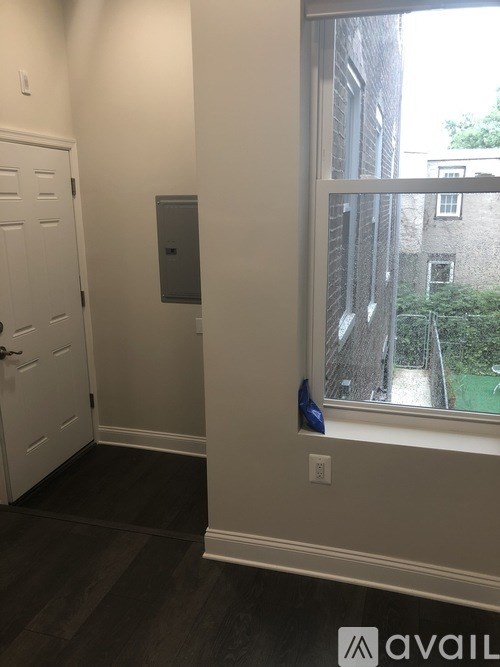 A room with a door and a window overlooking a backyard.