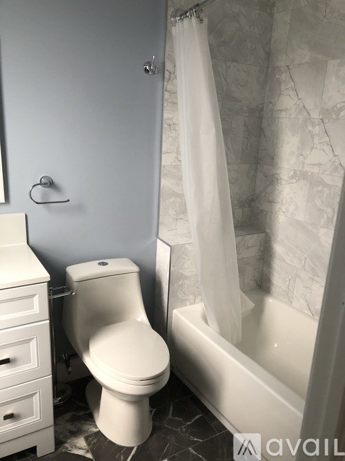 A white toilet sits next to a bathtub in a bathroom.