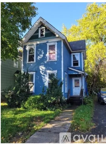 A blue house with a white door and windows.