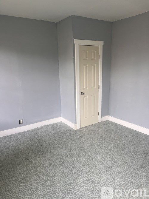 A room with a door and carpeted floor.