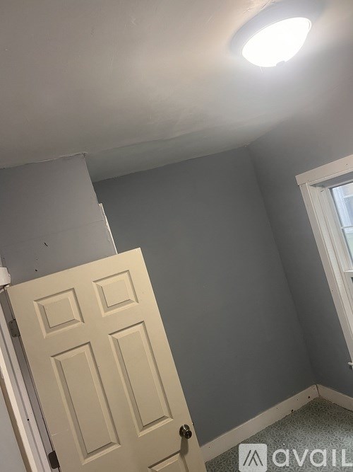 A white door is in a room with grey walls.