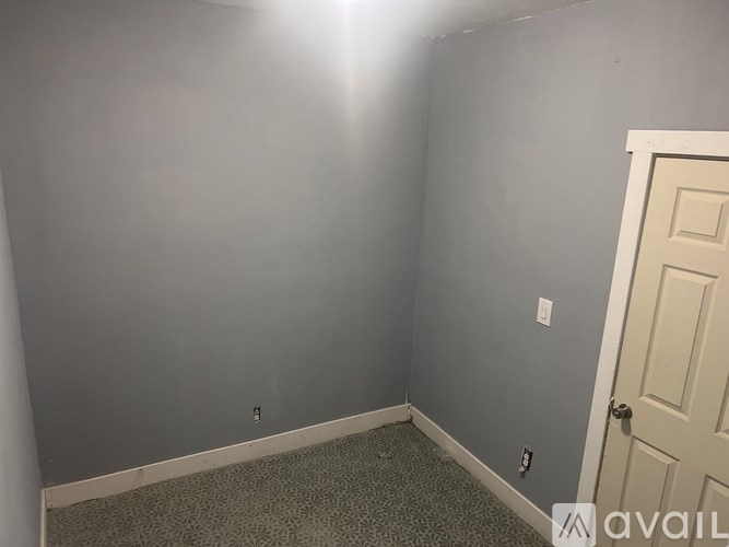 A room with a door and a light on the wall.