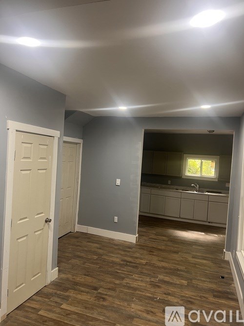 A room with a wooden floor and a white door.