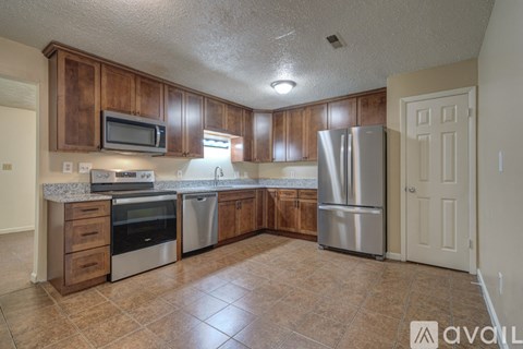 A kitchen with wooden cabinets and stainless steel appliances.