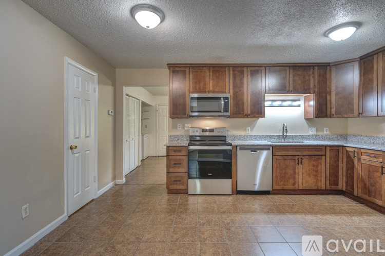 A kitchen with wooden cabinets and a tiled floor.