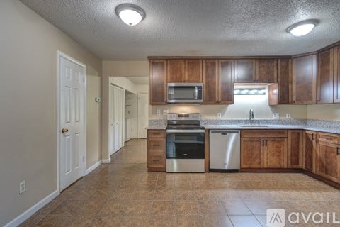 A kitchen with wooden cabinets and a tiled floor.