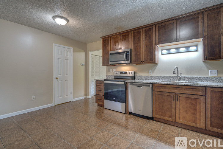 A kitchen with wooden cabinets and a tiled floor.
