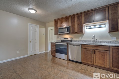 A kitchen with wooden cabinets and a tiled floor.