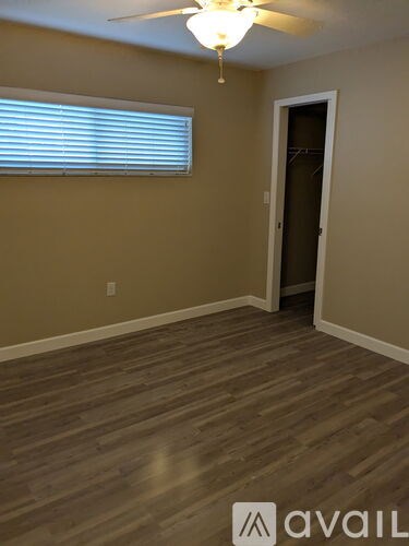A room with wooden flooring and a ceiling fan.