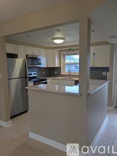 A kitchen with a refrigerator, microwave, and oven.