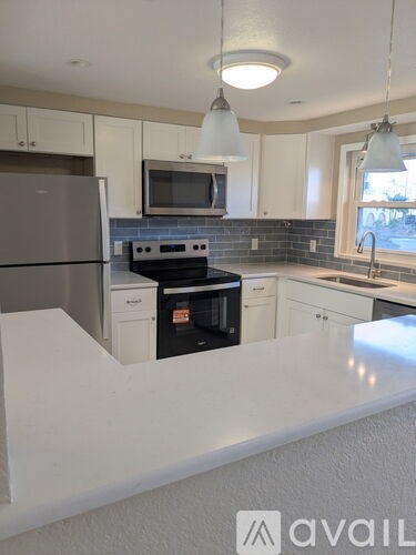 A kitchen with white cabinets and a black stove top oven.