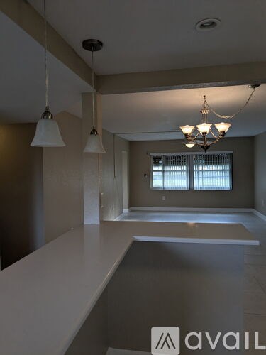 A room with a long table and a chandelier hanging from the ceiling.