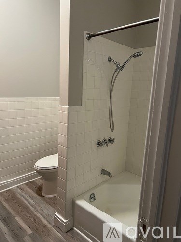 A bathroom with a toilet, a tub, and a shower.