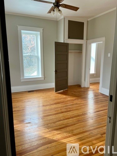 A room with wooden floors and a ceiling fan.