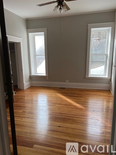 A room with wooden floors and a ceiling fan.