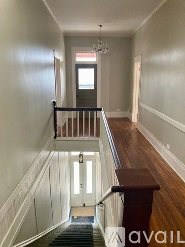 A hallway with a staircase leading to the second floor.