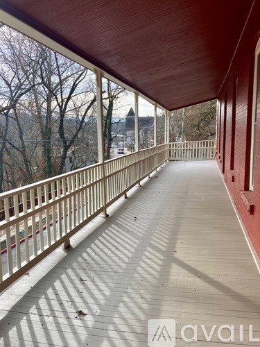A wooden deck with a railing and a view of trees and a body of water.