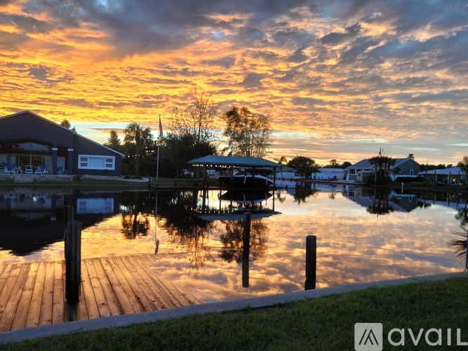 A serene dock with a sunset sky and buildings in the background.