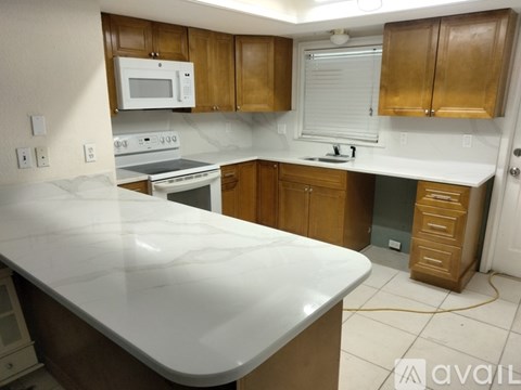 A kitchen with wooden cabinets and a white countertop.