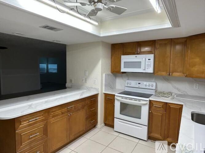A kitchen with wooden cabinets and white appliances.