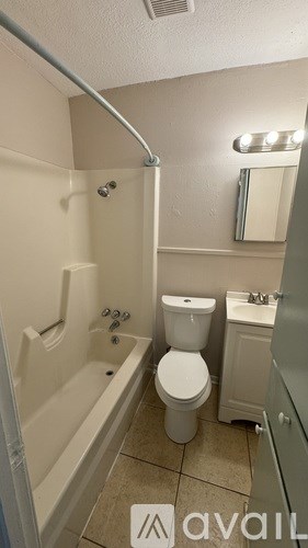 A bathroom with a toilet, sink, and bathtub.