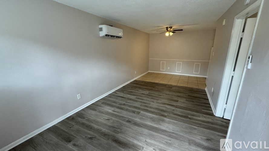 A room with a wooden floor and a ceiling fan.