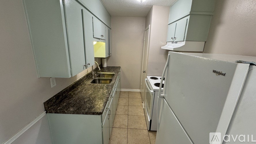A kitchen with granite countertops and a white refrigerator.