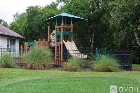A playground with a slide and a green canopy.