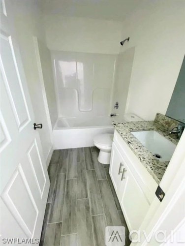 A bathroom with a white tub and a white toilet.