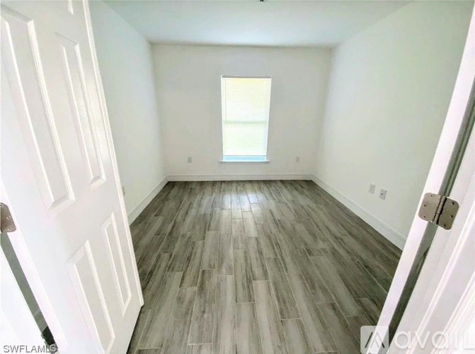 A room with a wooden floor and white walls.