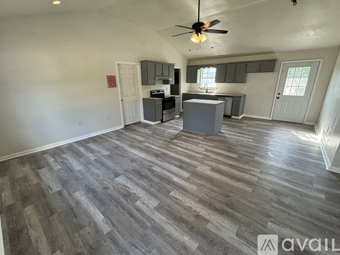 A room with a wooden floor and a ceiling fan.
