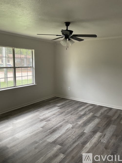 A room with a ceiling fan and a window.