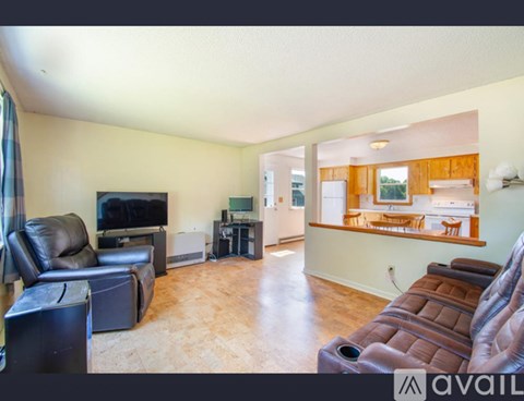 A living room with a brown leather couch and a television.