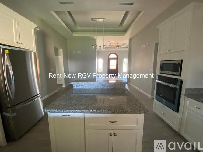 A kitchen with a refrigerator, microwave, and oven is on the market with RGV Property Management.