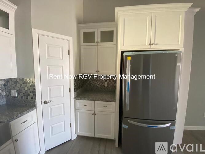 A kitchen with a refrigerator, cabinets, and a countertop.