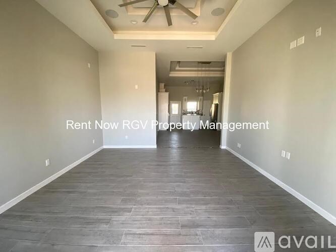 A spacious room with a ceiling fan and a sign that says "Rent Now RGV Property Management".