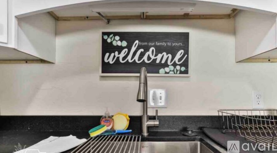 A kitchen with a sign that says "welcome" on the wall.
