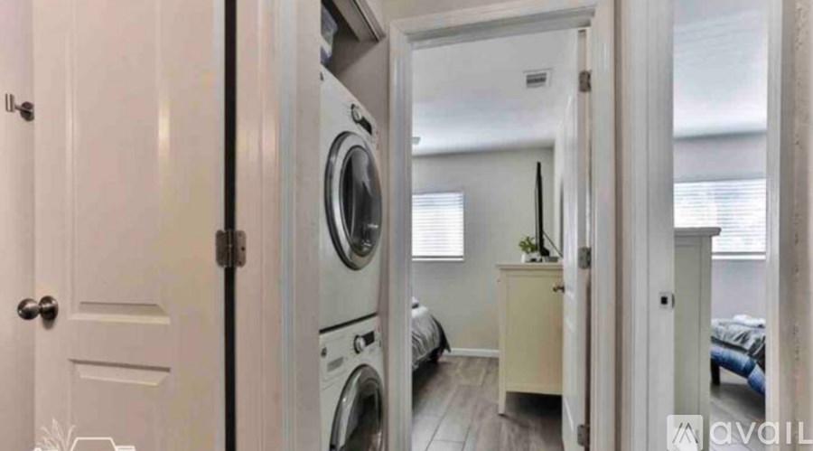 A small room with a washing machine and a bed.