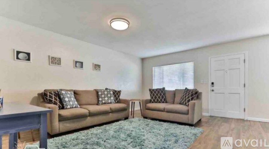 A living room with two couches and a rug.