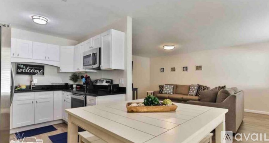 A kitchen with white cabinets and a wooden island.