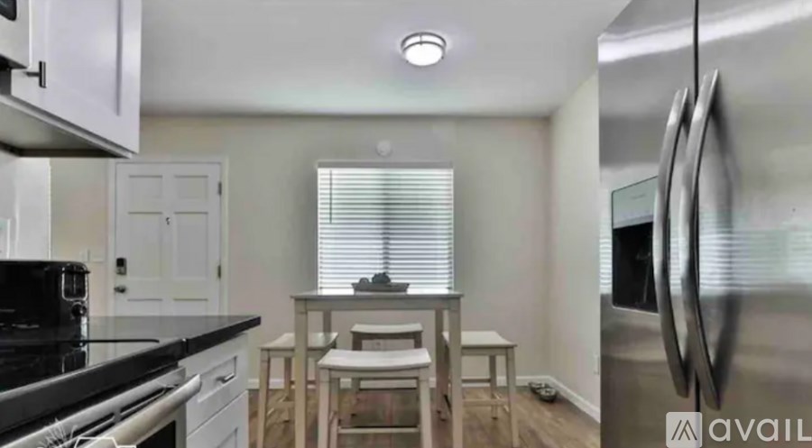 A modern kitchen with stainless steel appliances and a dining area.