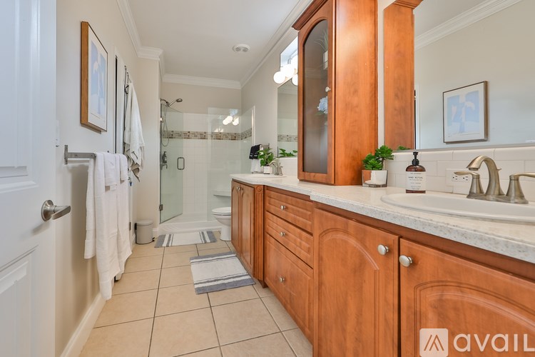 A bathroom with wooden cabinets and a glass shower stall.