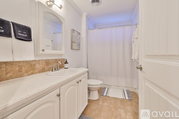 A bathroom with a toilet, sink, and shower curtain.