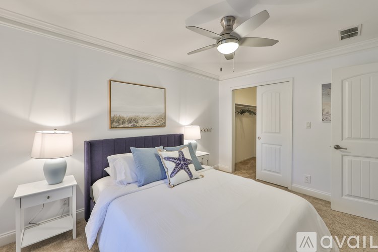 A bedroom with a bed, nightstand, and a ceiling fan.