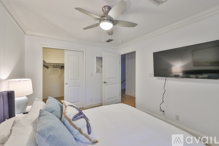 A bedroom with a large bed and a ceiling fan.